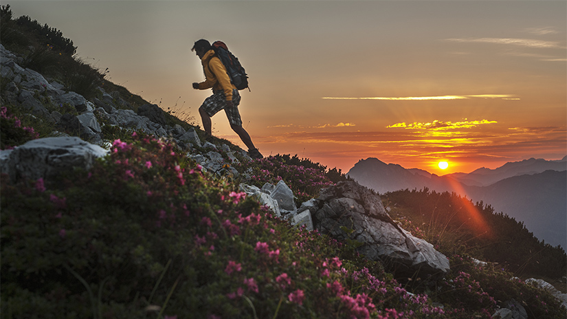 Man in yellow jacket enjoying Telluride hiking at sunrise.