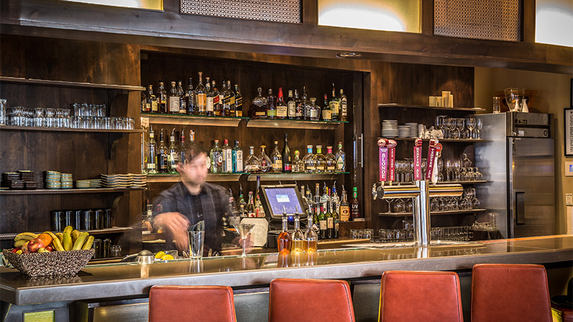 Bartender making drinks behind the counter at a local Telluride restaurant.