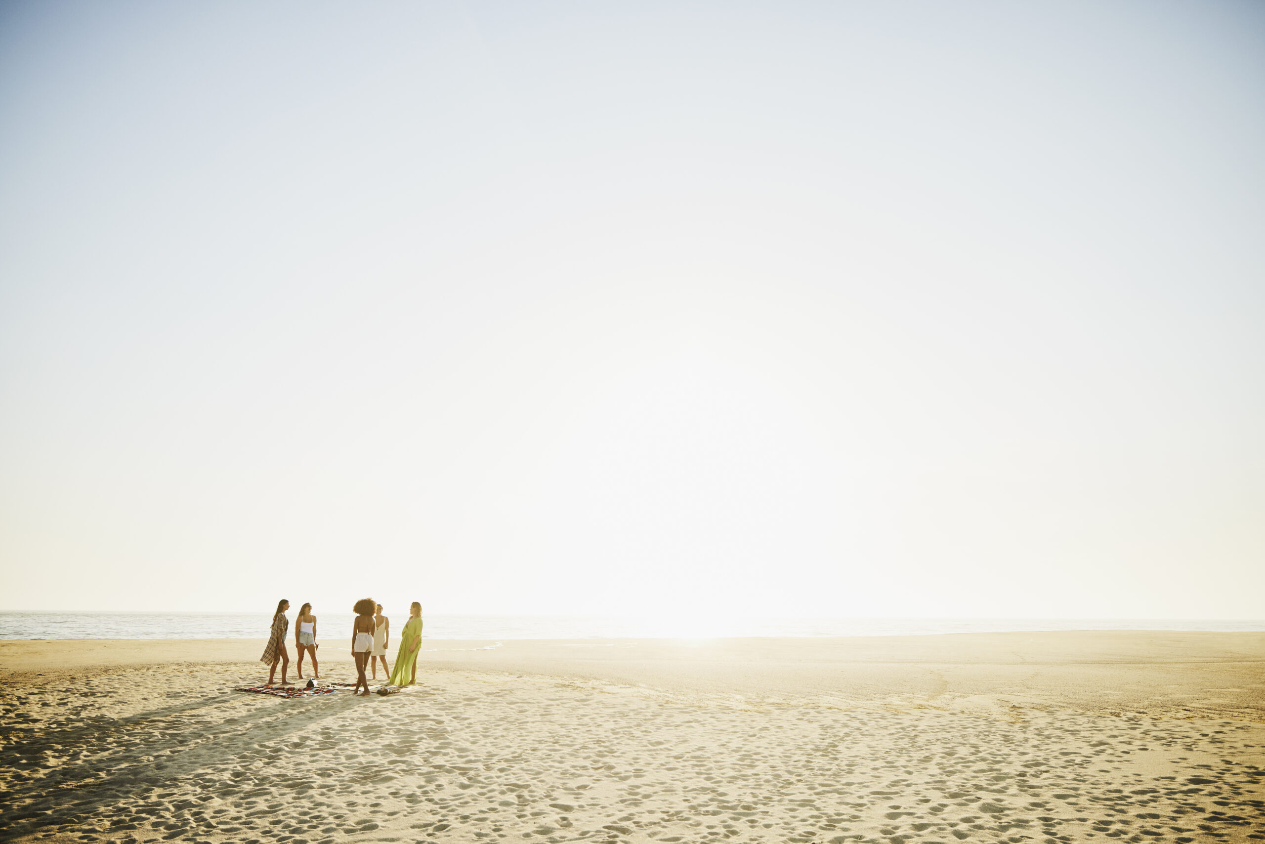 Group of female friends hanging out on the beach on an Inspirato luxury vacation.