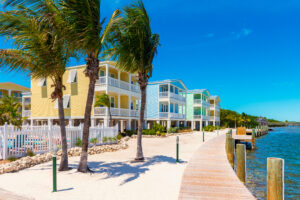 Pastel yellow, blue, and green waterfront beach homes lined up along dock in Florida Keys, Florida.