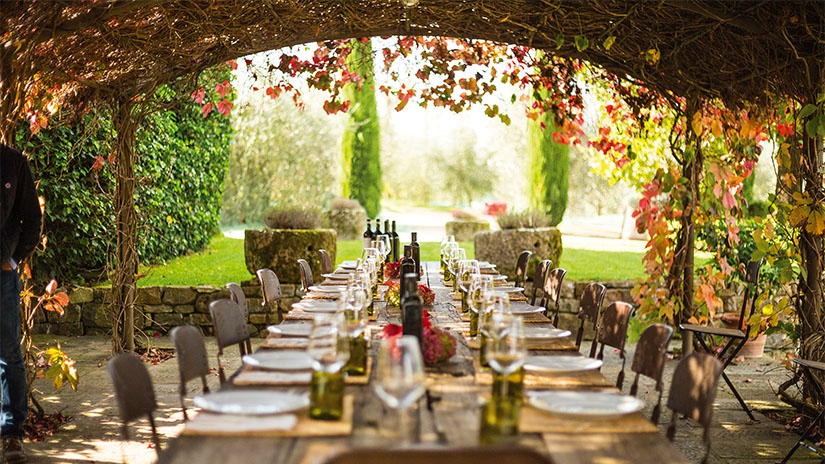 Dining table set at dusk at Inspirato partner winery Colle Bereto