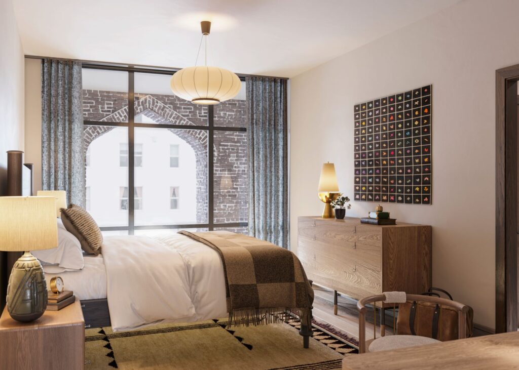 Chic bedroom at Bristow Inspirato home in Charleston historic district with neutral bedding and furnishings and large glass window.