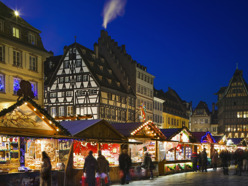 A market in the evening with a minimal amount of people looking at the stalls