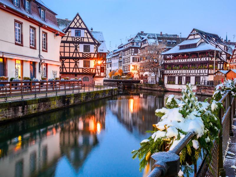 A small river in between buildings and a restaurant next to the river