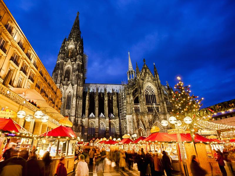 A European holiday market at night in front of a towering cathedral