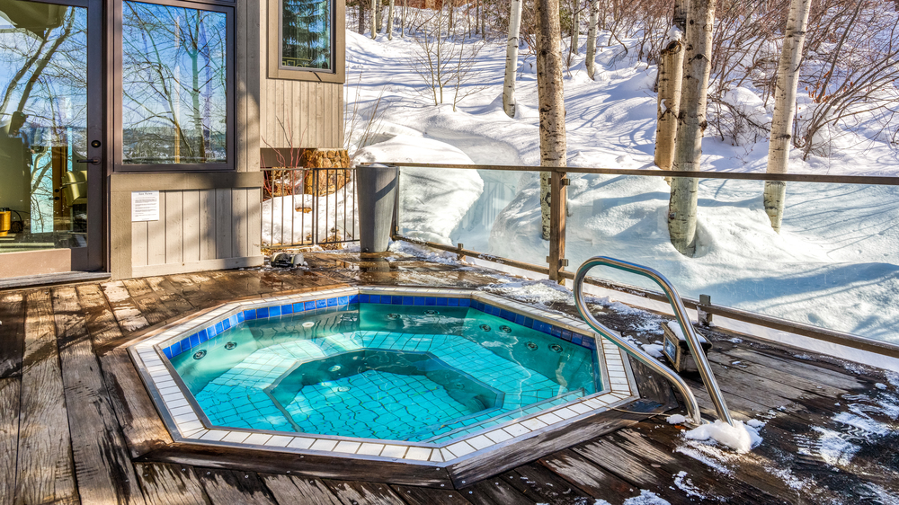 Sugar Ridge hexagon hot tub built into the porch with snow surrounding the home.