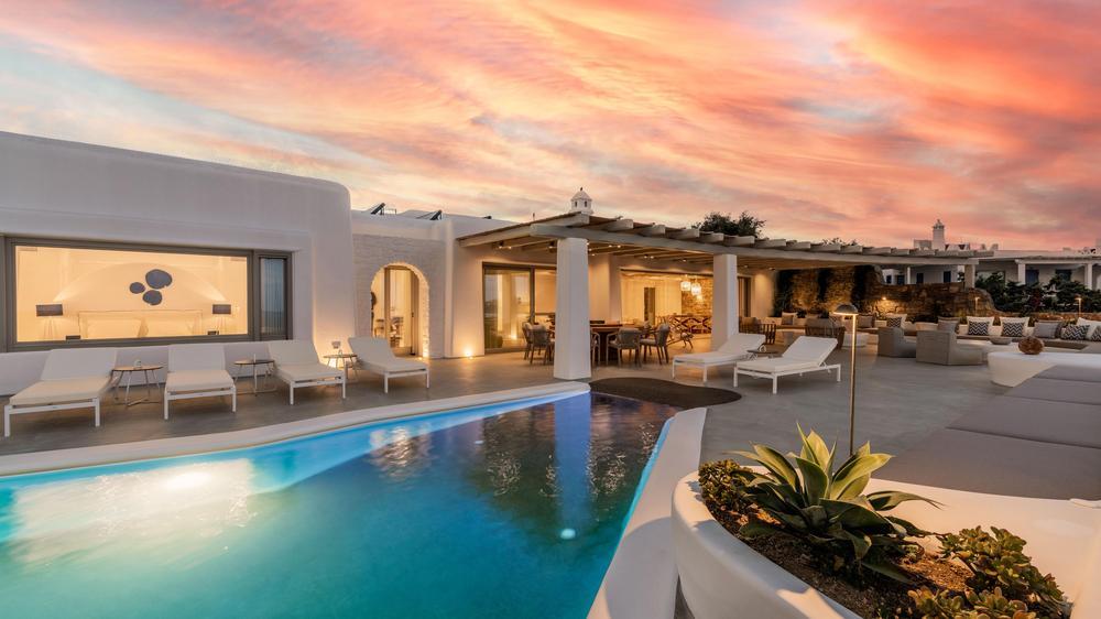 Pool area of Calliope with a pink sunset above the home.