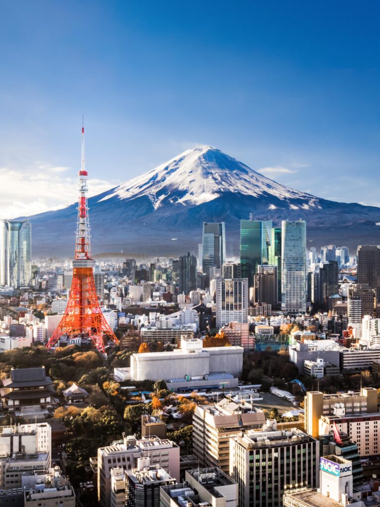 Aerial view of Mt. Fuji, Tokyo Tower and modern skyscrapers in Tokyo on a sunny day.