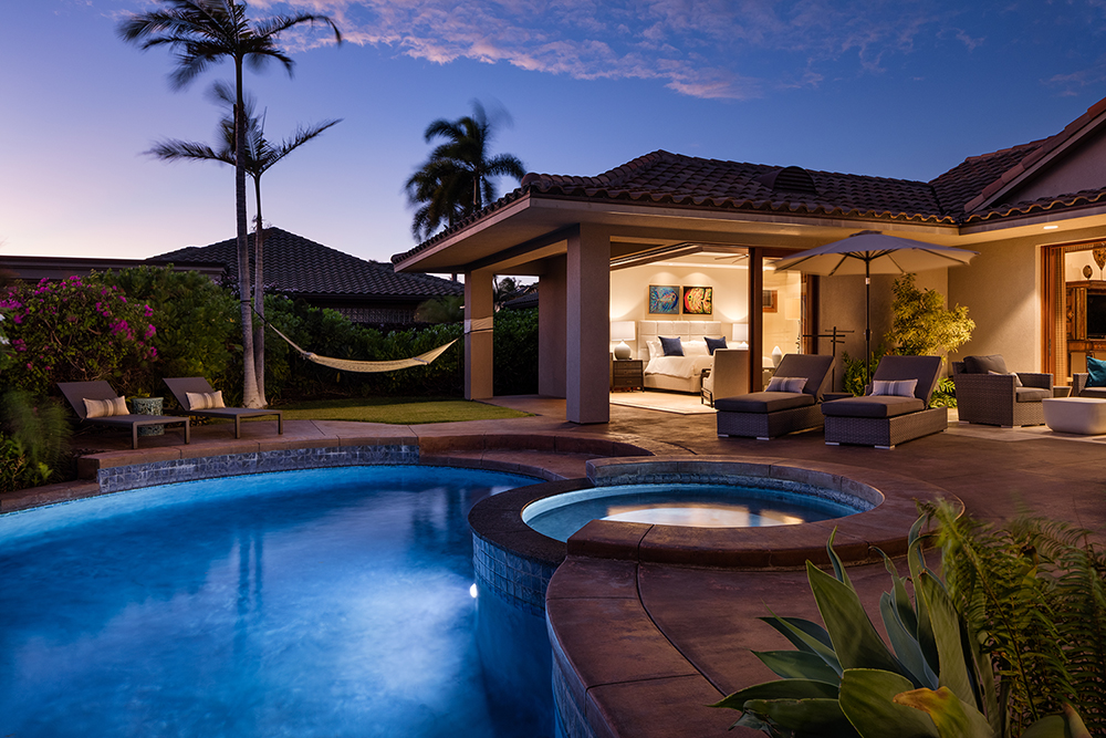 Luxury Hawaiian villa at dusk with private pool, hot tub, open-air bedroom, hammock, and tropical landscaping — perfect for upscale island retreats.