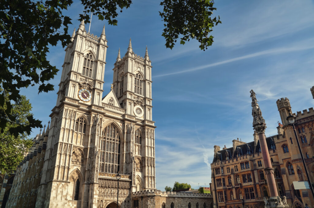 Westminster Abbey’s towering gothic architecture set against a blue sky, evoking spooky legends and haunted history perfect for a Halloween trip to London.
