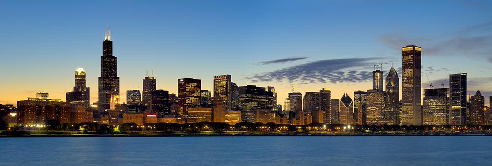 Chicago skyline at sunset reflecting over Lake Michigan — an Inspirato luxury city travel destination offering world-class culture, dining, and style.
