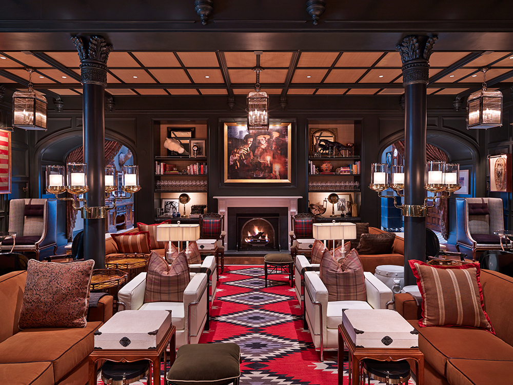 Sophisticated lodge-style lounge at Hotel Jerome in Aspen, Colorado, featuring rich textures, a roaring fireplace, and cinematic Western-inspired décor.