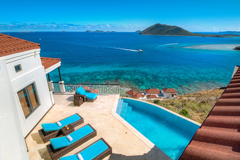 Luxury oceanfront villa on Scrub Island with infinity pool overlooking turquoise Caribbean waters and nearby islands — an Inspirato Signature beach destination for a high-end tropical getaway.