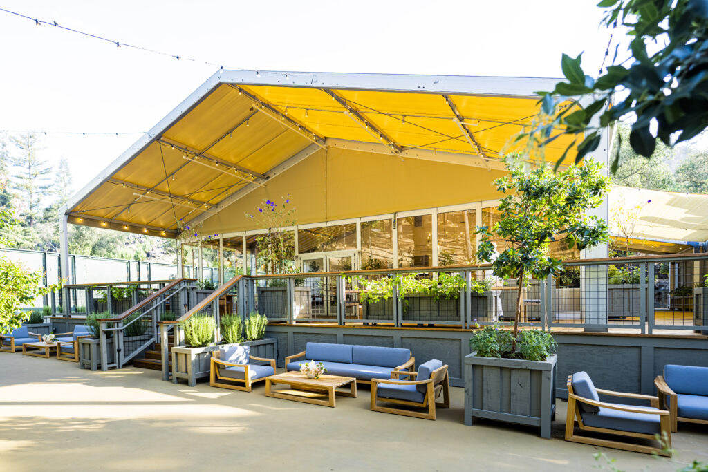 Outdoor terrace with modern lounge seating and garden planters at The Forum at Meadowood Napa Valley, part of a Three Michelin Key luxury resort offering elevated wine country experiences in California.