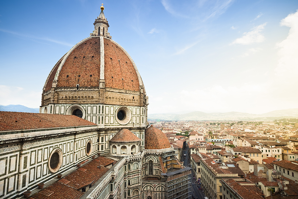 Close-up view of Florence’s iconic Duomo cathedral with its terracotta dome overlooking the city’s rooftops, showcasing Tuscany’s rich history and architecture for a luxury spring vacation in Italy.