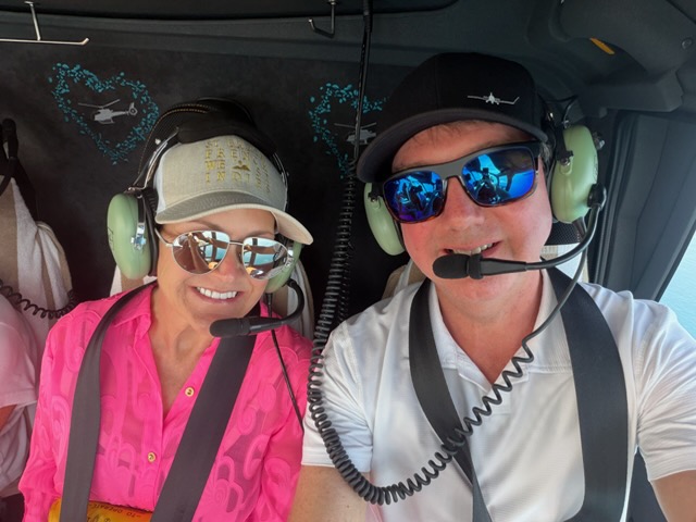 The Willises smiling for a selfie aboard their helicopter in Australia