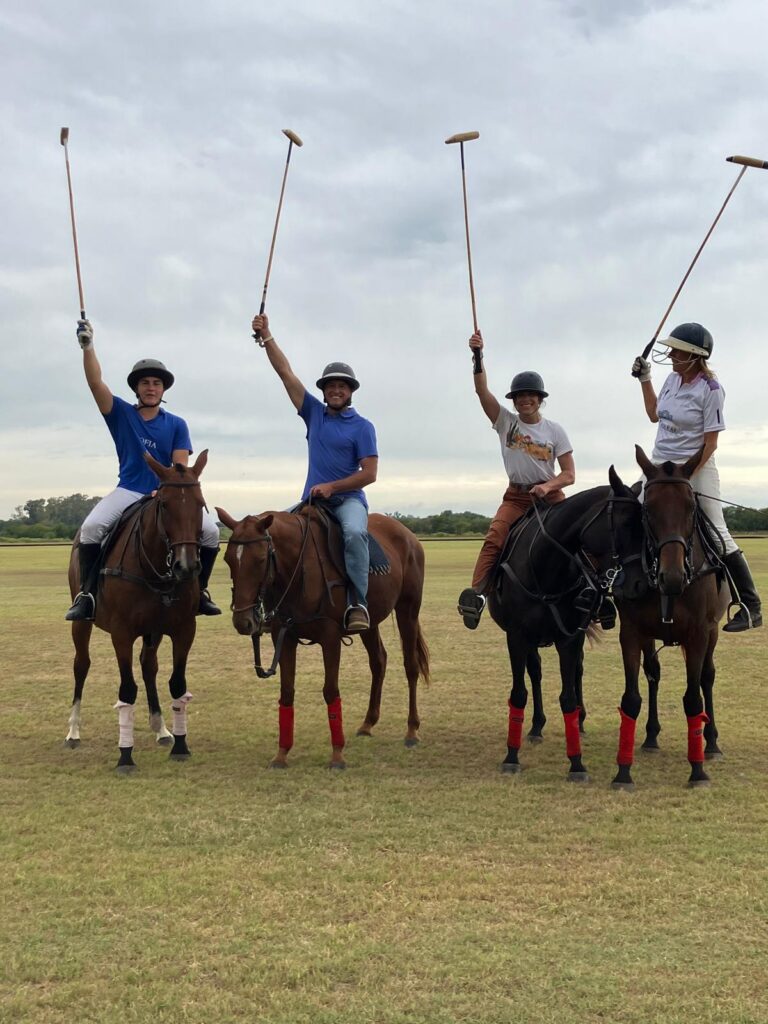 Four polo players posed on their horses