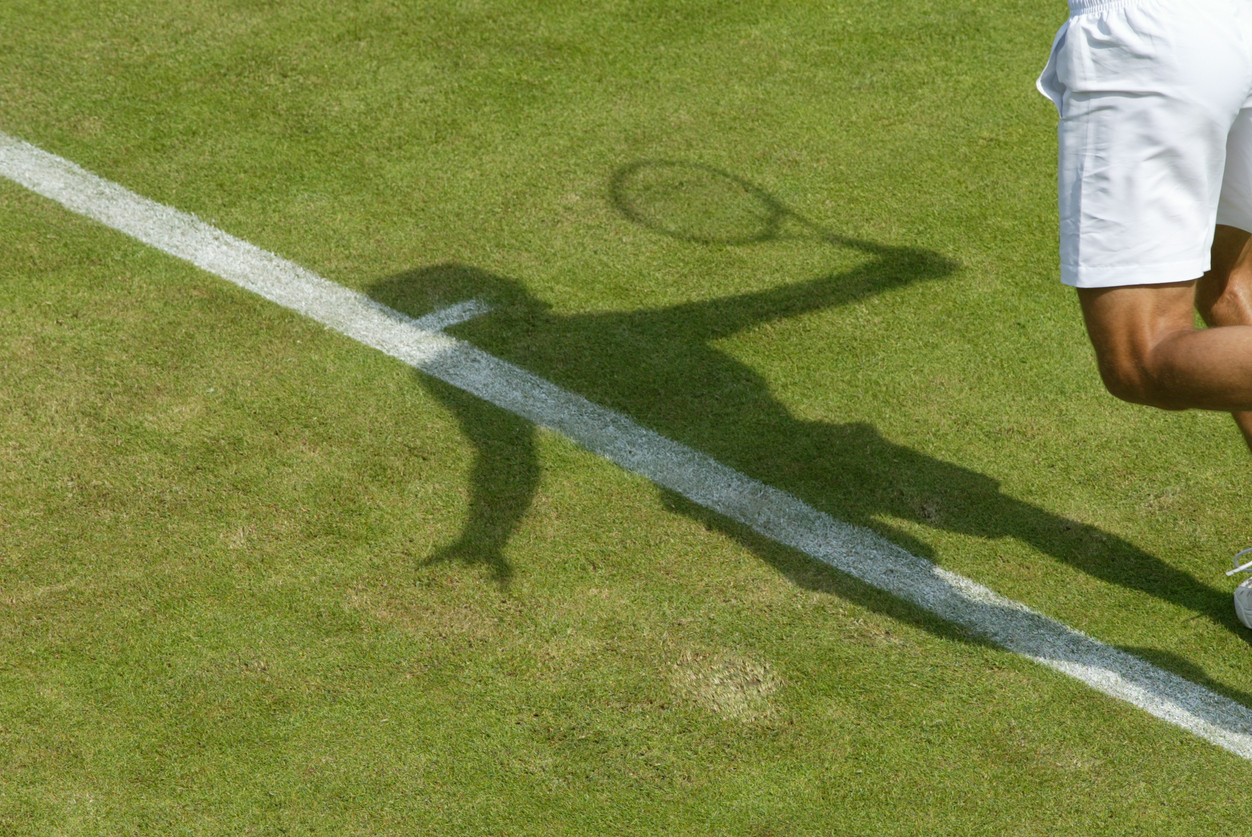 shadow of a tennis player on the grass court at Wimbledon