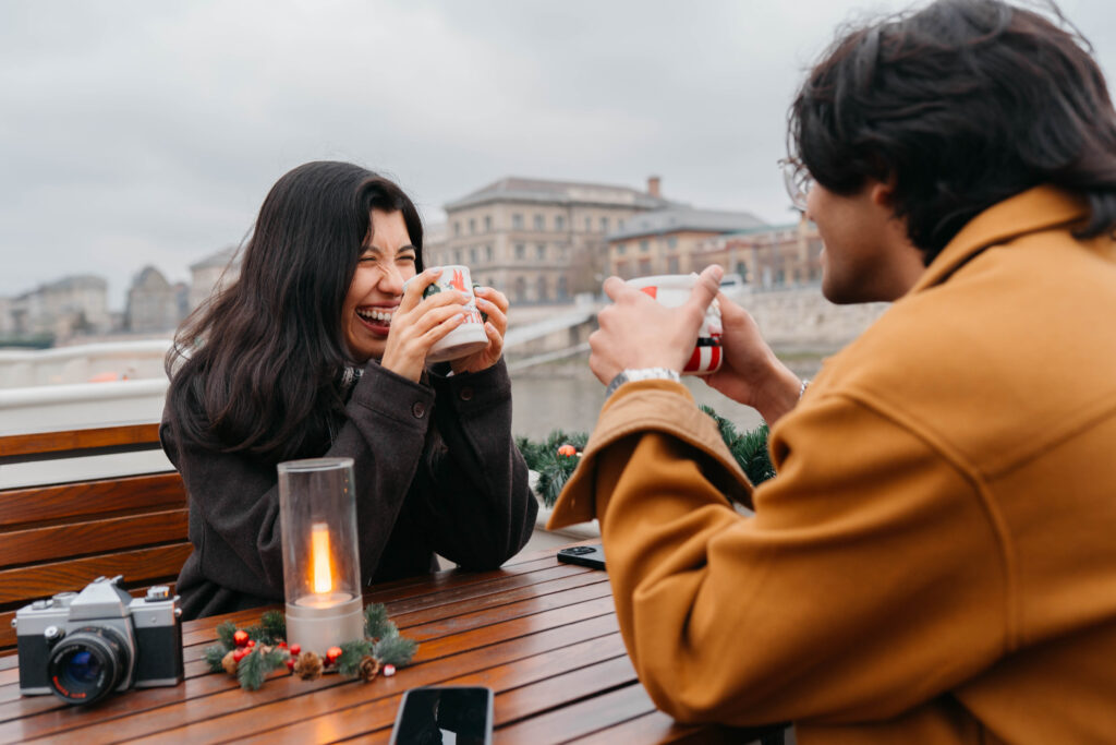 A couple laughing and drinking along the Danube
