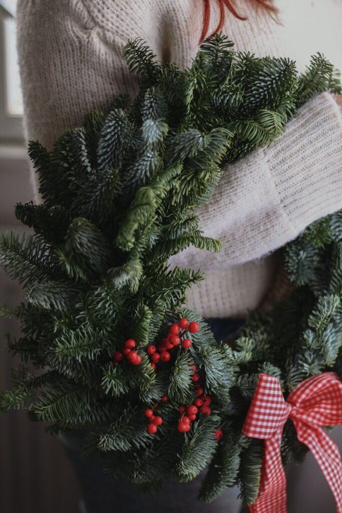 Close-up of a woman holding a holiday wreath